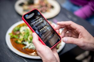 A close-up of a person rating their experience at a restaurant using a smartphone app.