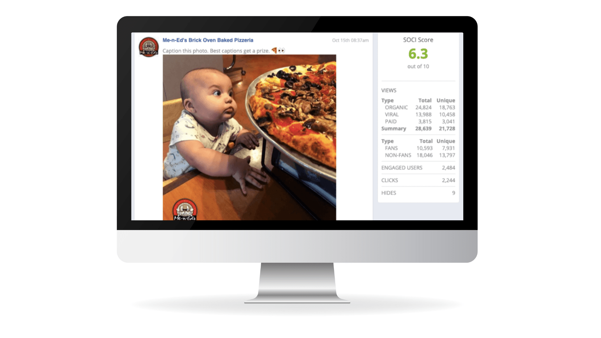 A baby excitedly reaches for a giant pizza on a table, displayed on a computer screen.