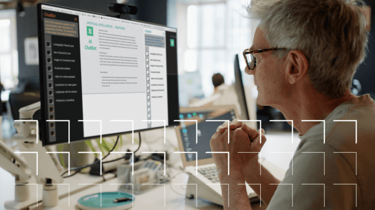 An older person looking at AI chatbot and software on a desktop screen in an office setting.