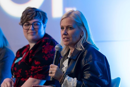 Ace Hardware CMO Kim Lefko speaks on stage as Christine “CG” Millier looks on