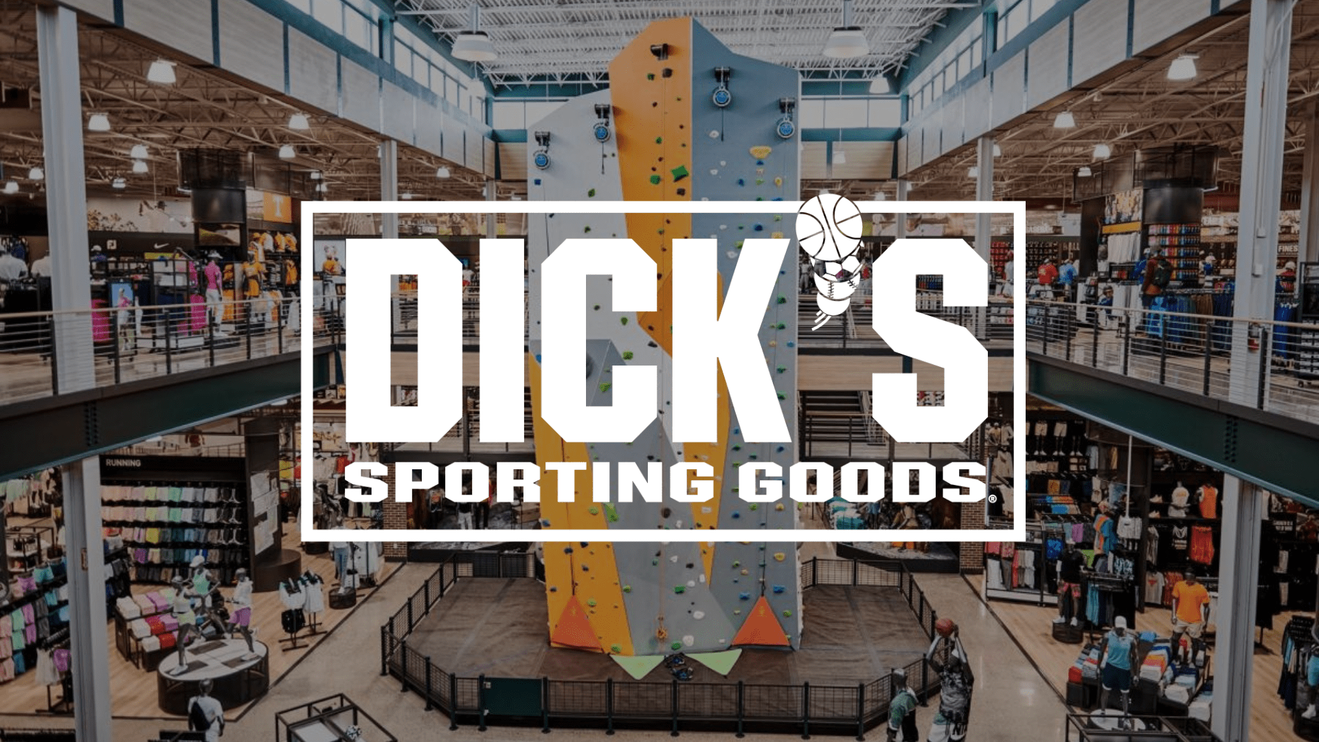 An indoor rock climbing wall surrounded by two stories of retail space with an overlay of the Dick's Sporting Goods logo.